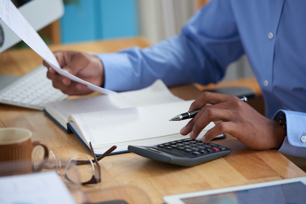 Attorney reviewing documents with a calculator
